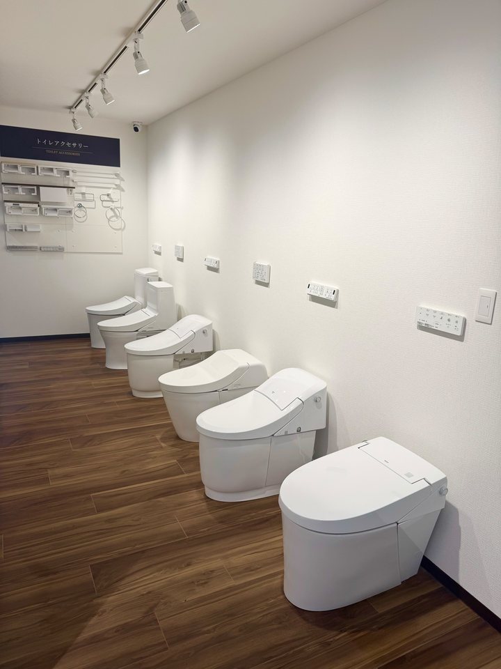 ショールームに並んでいるトイレの展示と、奥の壁のトイレアクセサリーのサンプル